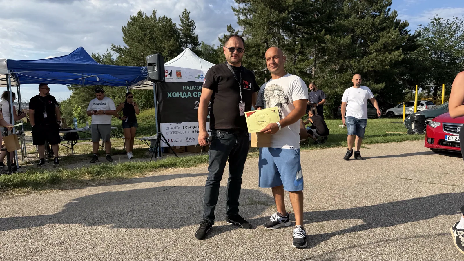 Двама участници с грамота пред банера на клуба на Национална Хонда Среща 2026